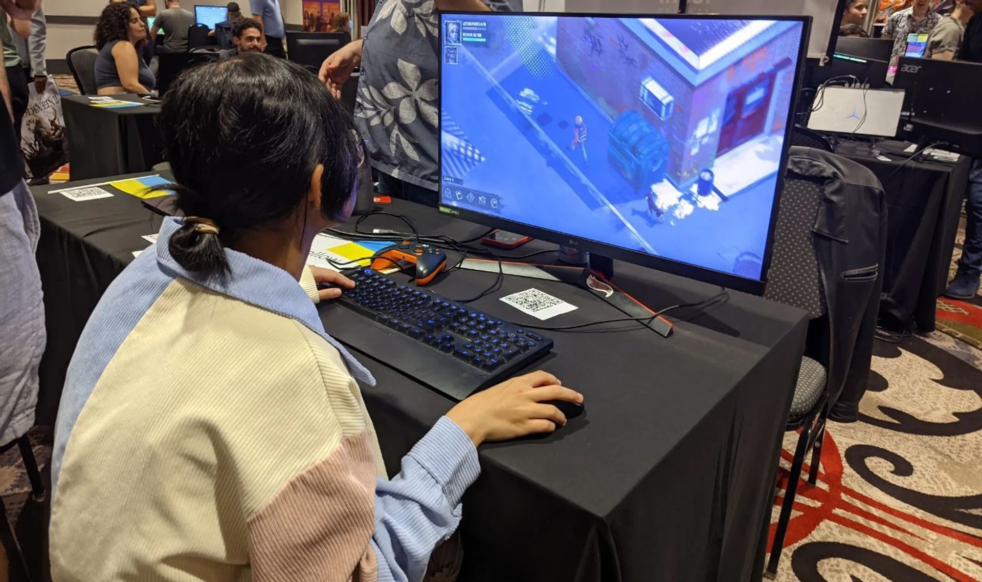 Відвідувач Seattle Indies Expo 2025 грає у Hollow Home на стенді Ukrainian Games Festival