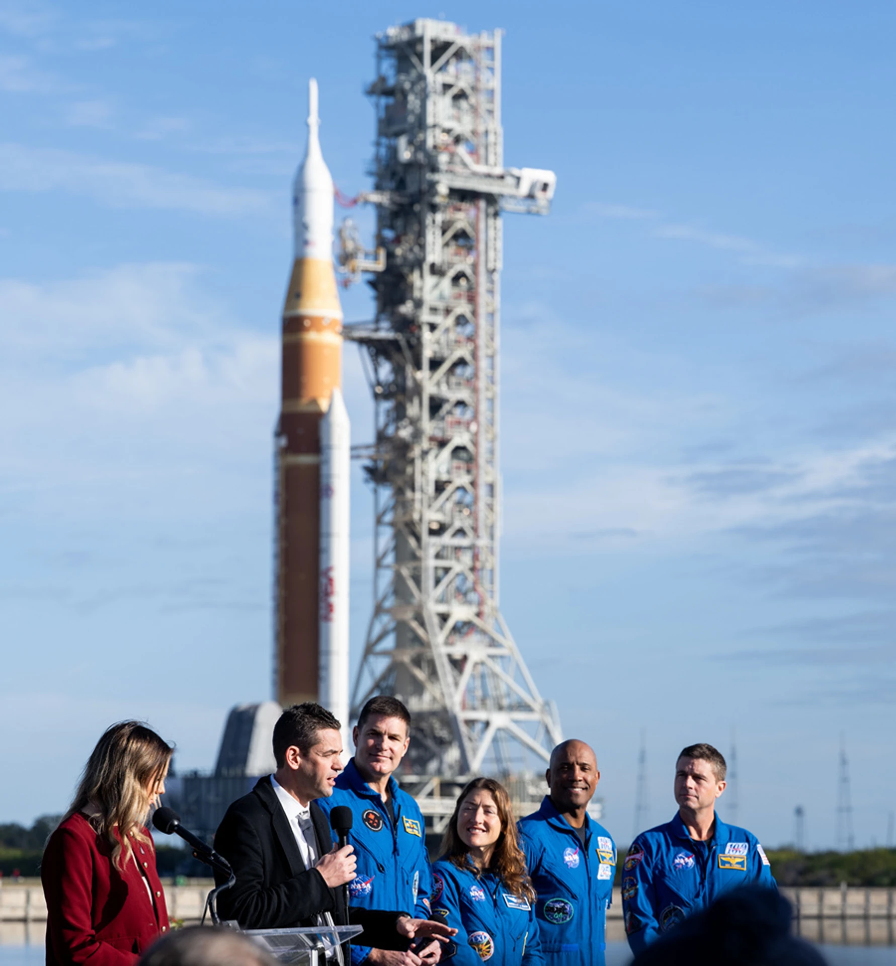 Команда Artemis II та адміністратор NASA на фоні ракети-носія SLS, 17 січня 2026 року. Зліва направо: адміністратор NASA Джаред Айзекман, астронавти Джеремі Гансен (Канада, спеціаліст), Крістіна Кох (США, спеціаліст), Віктор Гловер (США, пілот) та Грегорі Рейд Уайсмен (США, командир корабля)