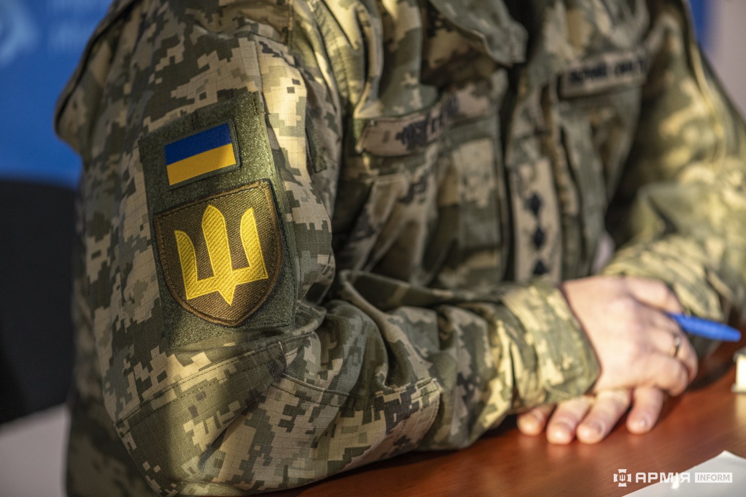 Крупний план шеврона з Державним Гербом України та прапора на рукаві піксельної форми військовослужбовця