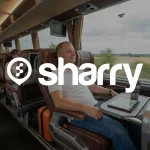 Sharry на фоні чоловіка, який сидить на коричневому шкіряному сидінні мінібусу