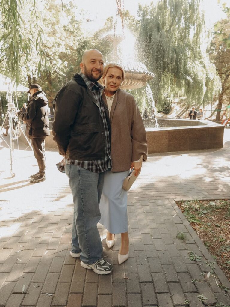 пара театральних програм, рукописна записка та вінтажна камера на дерев'яному ящику