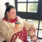 символічна предметна сцена з пов'язкою, мікрофоном і нотами на простій поверхні