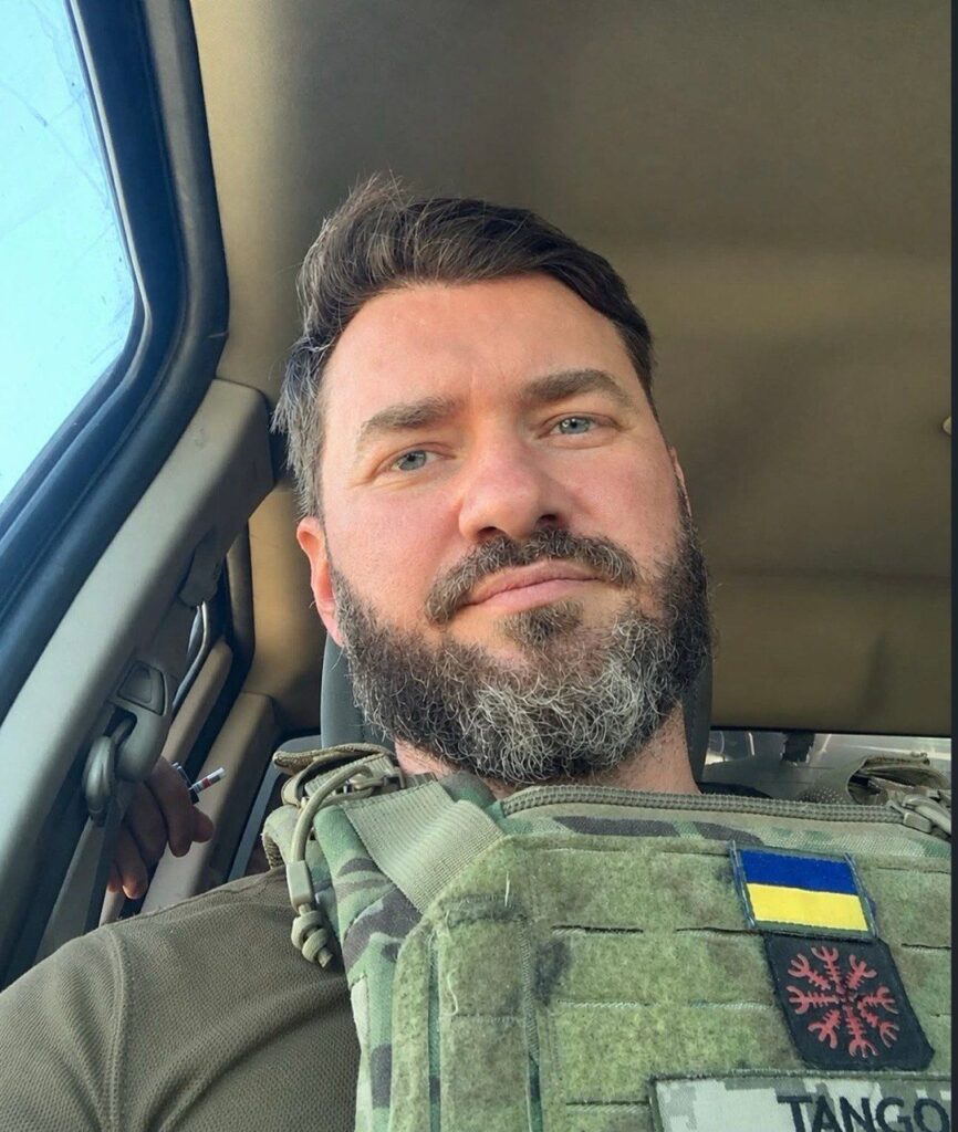 військова куртка на стільці поруч із простою вітальною листівкою, приглушені кольори