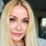 предметна сцена з архівними фото, стрічкою та брошкою, теплі тони
