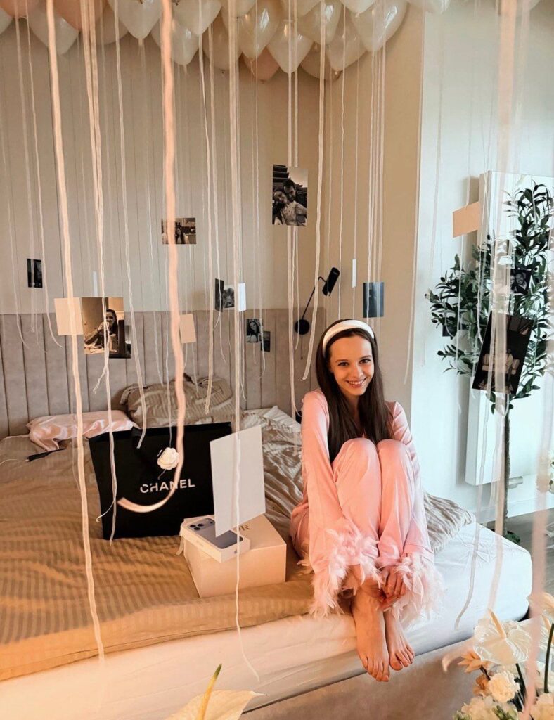 подарункові коробки Dior, Chanel та Apple на столі серед троянд і кульок