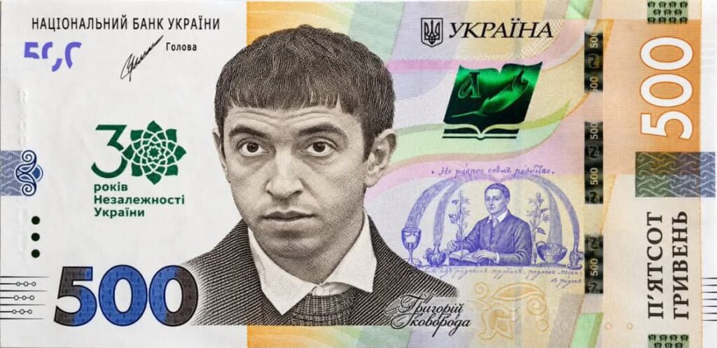 Атрибутна сцена: гребінець із рівним чубчиком на білій сорочці та сірому светрі, нейтральне тло