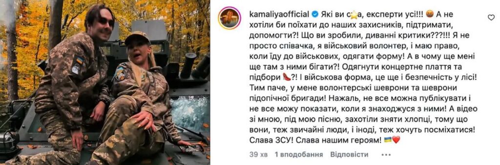 взуття, ноти та волонтерський шеврон на дерев'яній поверхні