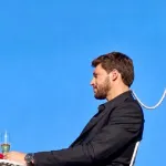 Вінтажний телевізор, стопка паперових мемів і червона троянда на тлі
