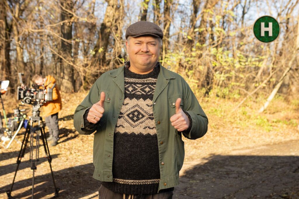 м'яч, кросівки та телевізійна програмка на деревʼяній лаві